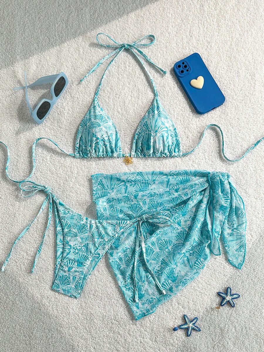 Women's 3-piece blue tropical shell print bikini set featuring a halter bralette top, low-waist tie-side bottom, and a matching sheer mesh cover-up skirt.