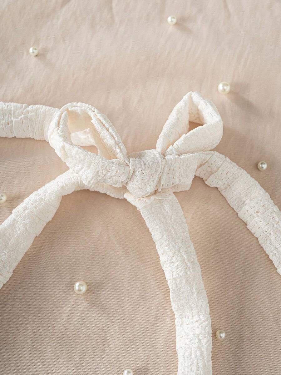 Apricot tween girls sleeveless halter cami dress with appliques, bow front, zipper detail, high waist, flared hem, and short slim fit design.
