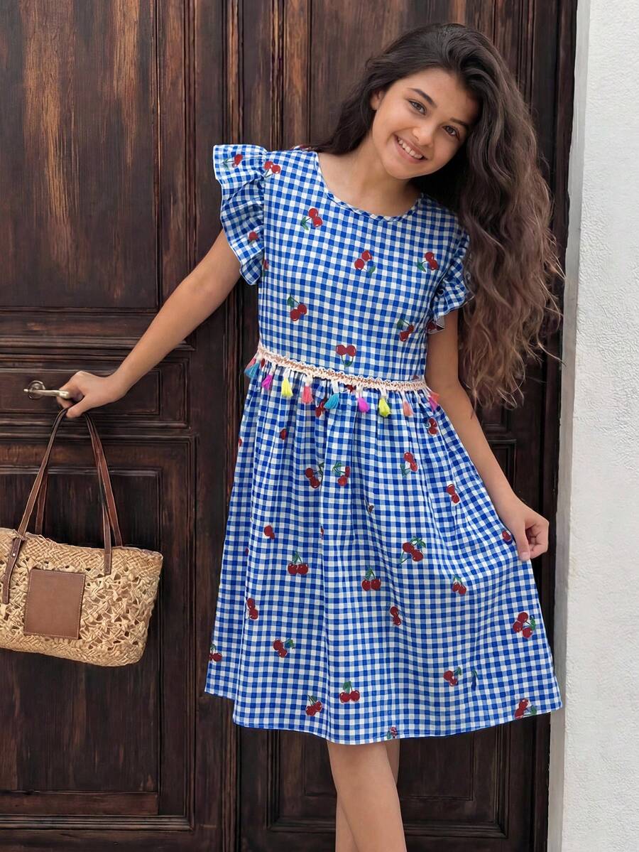 Tween girls blue short smock dress featuring flounce short sleeves, high waist flared hem, round neck, and front bow detail.
