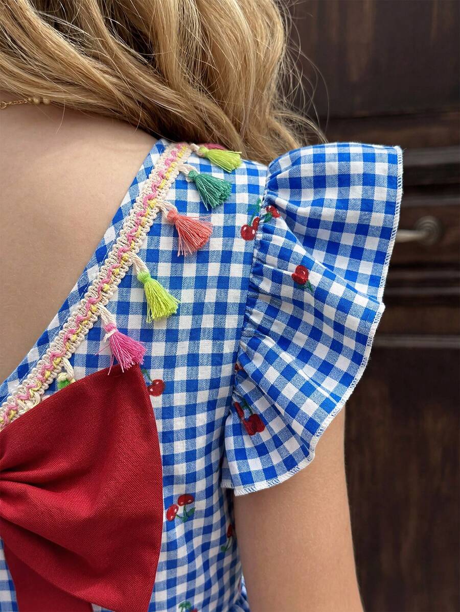 Tween girls blue short smock dress featuring flounce short sleeves, high waist flared hem, round neck, and front bow detail.
