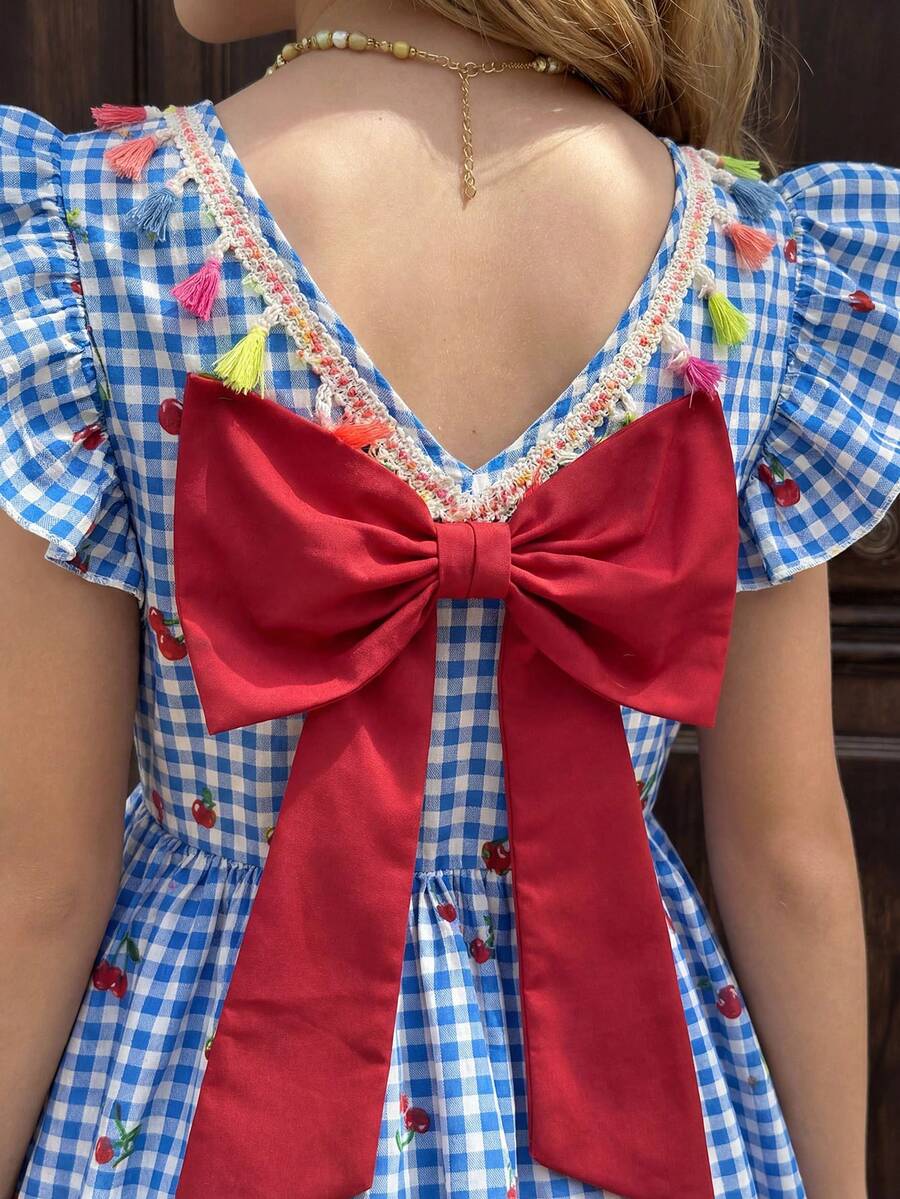 Tween girls blue short smock dress featuring flounce short sleeves, high waist flared hem, round neck, and front bow detail.