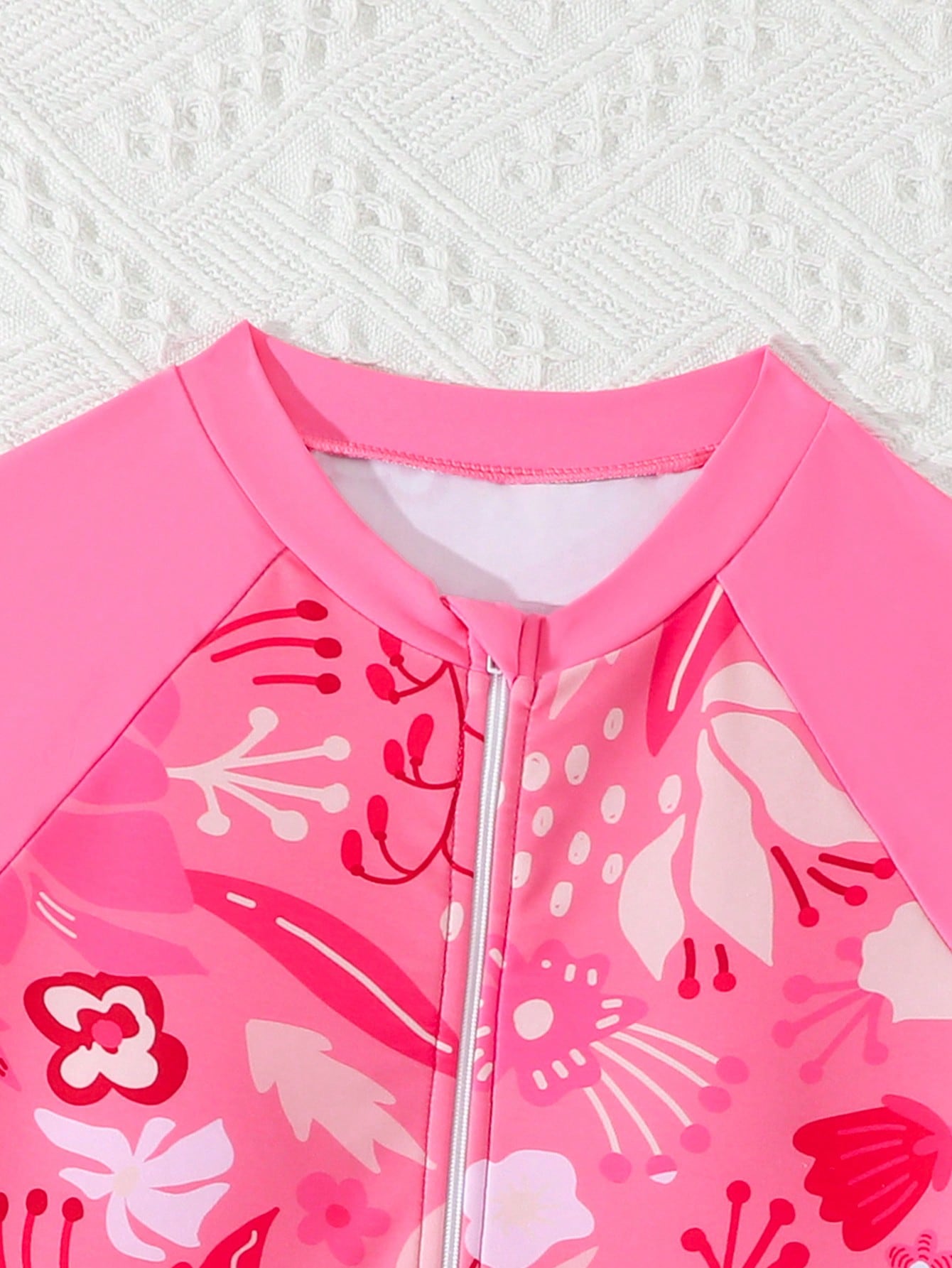 Tween girls one-piece swimsuit featuring a high neck, long sleeves, and shorts bottom, with a back zipper and strawberry plaid digital print on stretch knit fabric. Designed for swimming, vacation, and summer wear.