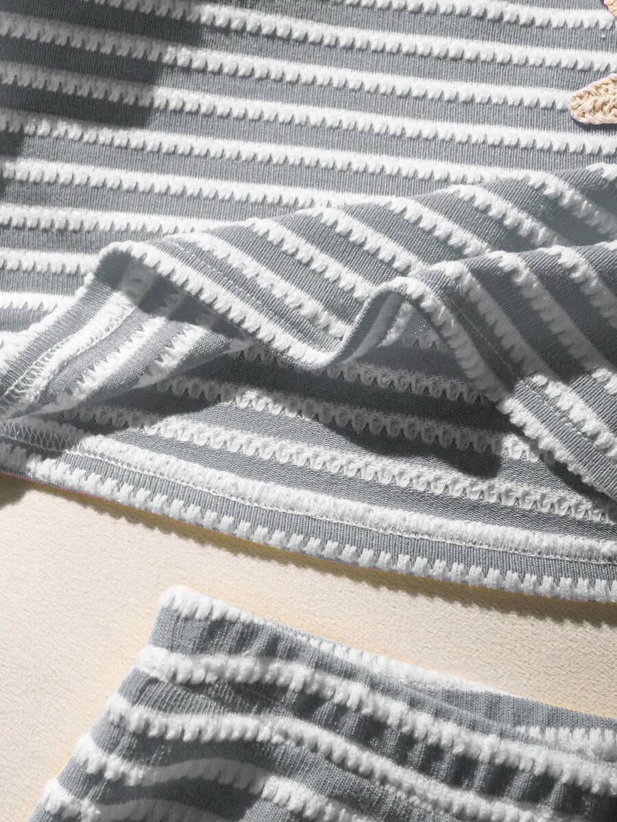 Tween girls black and white striped two-piece set featuring a spaghetti strap micro crop tank top with lettuce trim and ruffle hem paired with matching slim fit shorts.