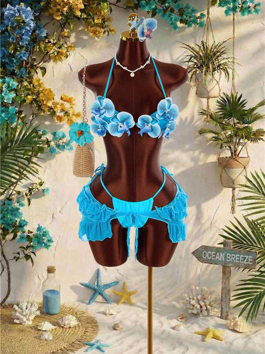Women's 3-piece blue bikini swimwear set featuring a crop top with 3D rose accents, tie back detail, spaghetti straps, and tie-side bottoms.