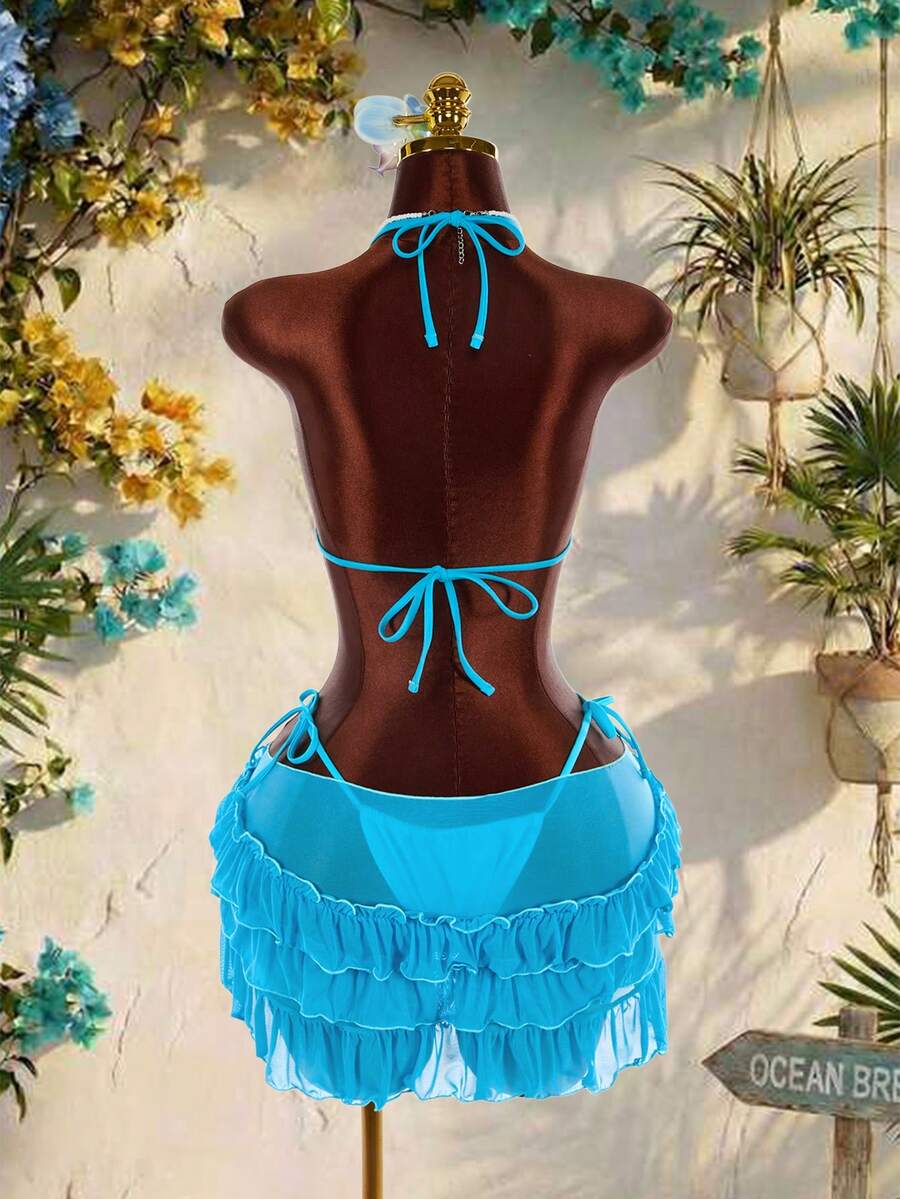 Women's 3-piece blue bikini swimwear set featuring a crop top with 3D rose accents, tie back detail, spaghetti straps, and tie-side bottoms.