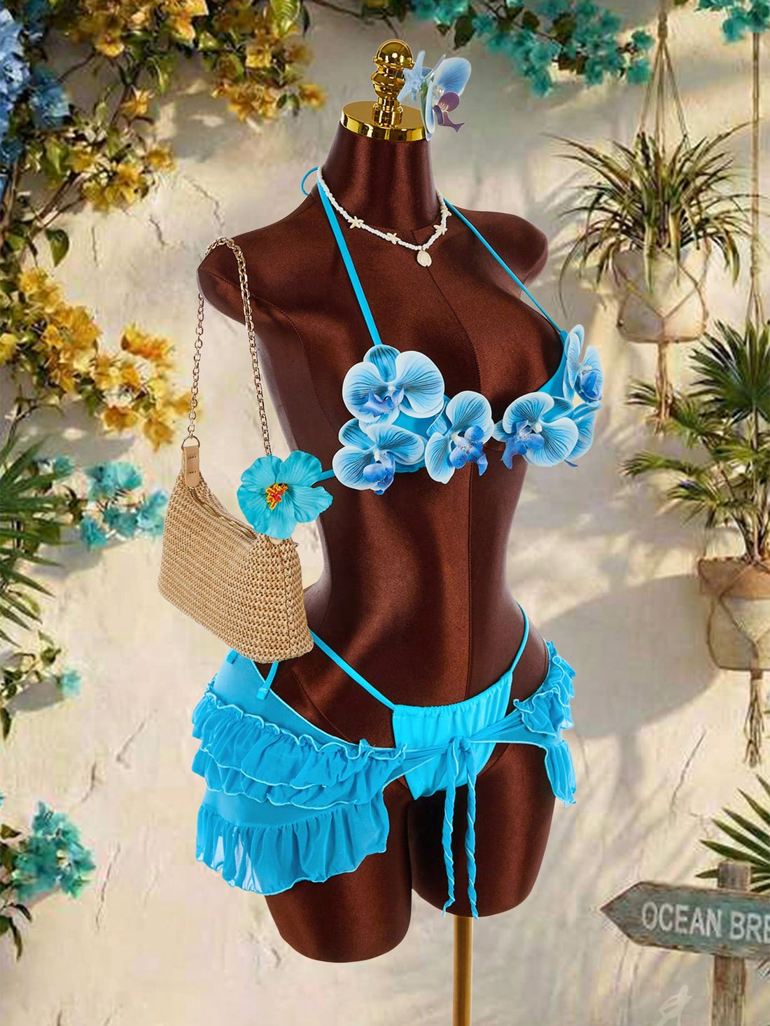 Women's 3-piece blue bikini swimwear set featuring a crop top with 3D rose accents, tie back detail, spaghetti straps, and tie-side bottoms.