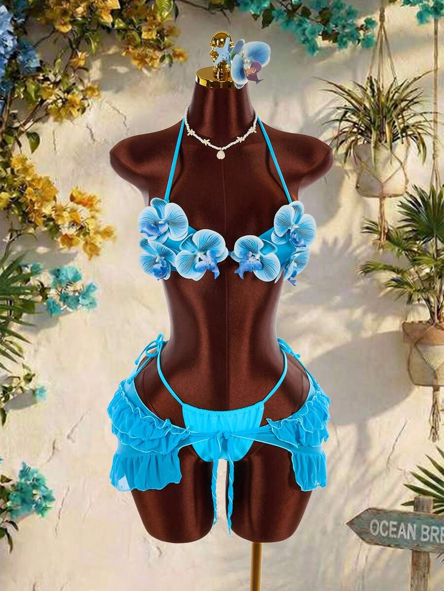 Women's 3-piece blue bikini swimwear set featuring a crop top with 3D rose accents, tie back detail, spaghetti straps, and tie-side bottoms.