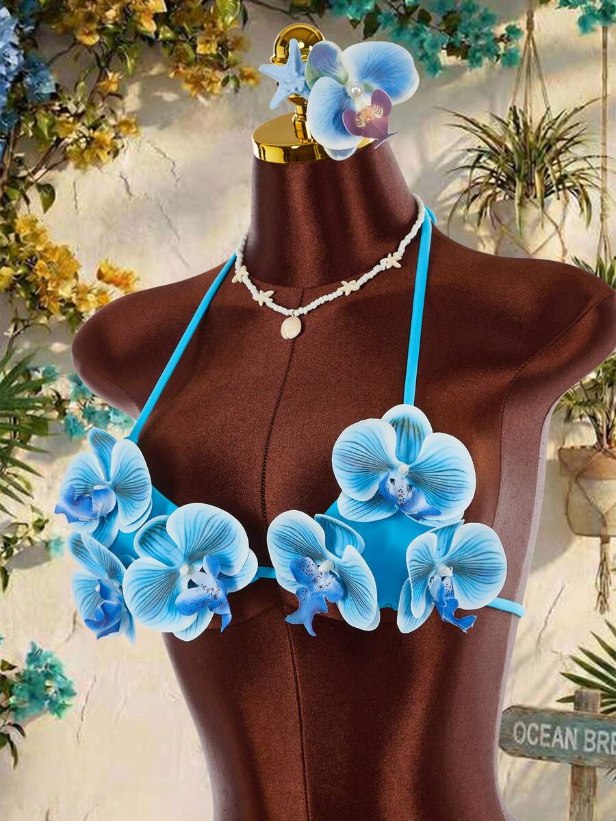 Women's 3-piece blue bikini swimwear set featuring a crop top with 3D rose accents, tie back detail, spaghetti straps, and tie-side bottoms.