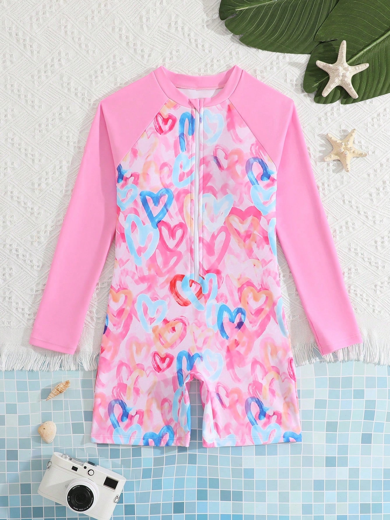 Tween girls one-piece swimsuit featuring a high neck, long sleeves, and shorts bottom, with a back zipper and strawberry plaid digital print on stretch knit fabric. Designed for swimming, vacation, and summer wear.