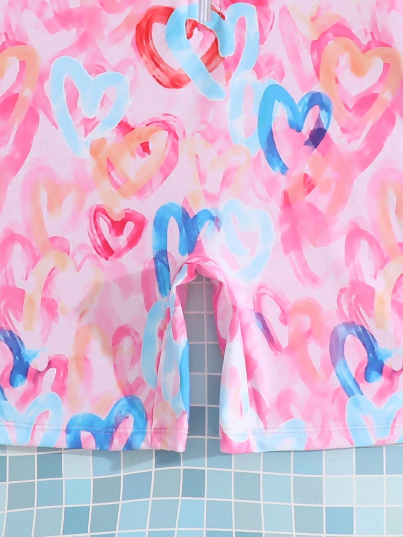 Tween girls one-piece swimsuit featuring a high neck, long sleeves, and shorts bottom, with a back zipper and strawberry plaid digital print on stretch knit fabric. Designed for swimming, vacation, and summer wear.