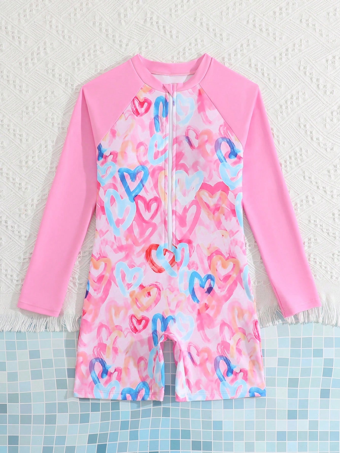Tween girls one-piece swimsuit featuring a high neck, long sleeves, and shorts bottom, with a back zipper and strawberry plaid digital print on stretch knit fabric. Designed for swimming, vacation, and summer wear.