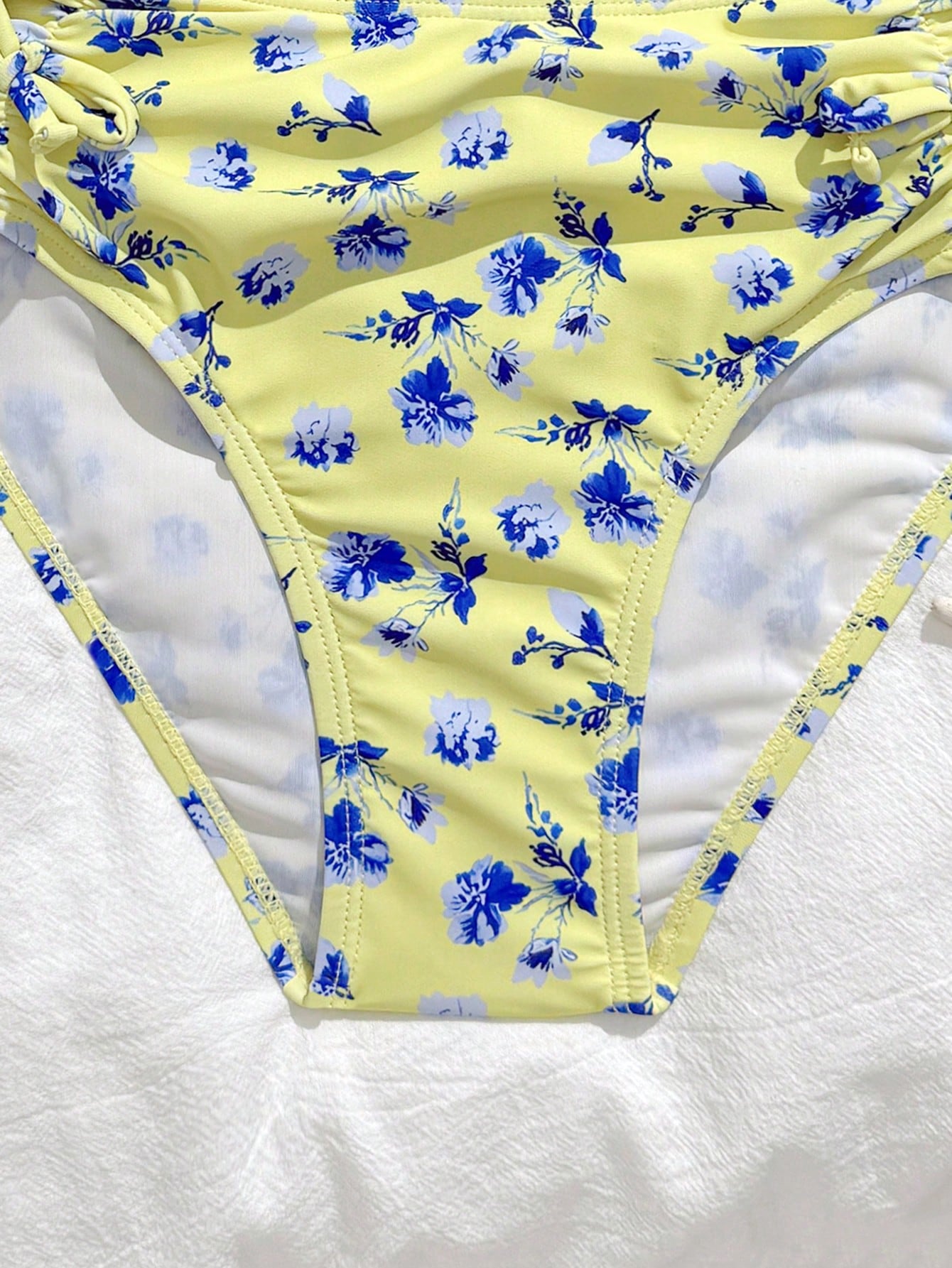 Tween girls 2-piece ditsy floral bikini set featuring a spaghetti strap top with center string detail and matching bottoms with side strings, designed for swimming, vacation, and summer wear.