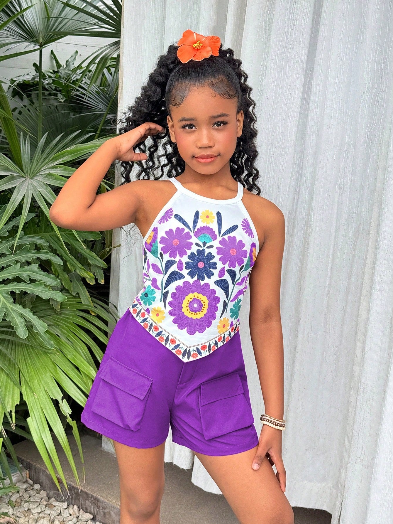 Girls 2-piece vacation outfit set with sleeveless halter knit crop top and graphic cargo shorts.