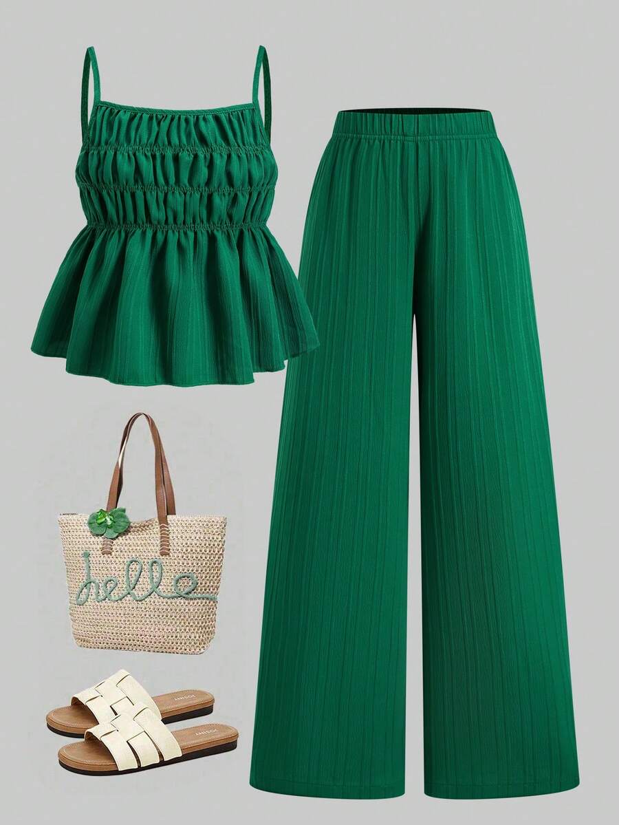 Tween girl wearing an apricot 2-piece outfit set featuring a shirred spaghetti strap short cami top and matching wide-leg long pants.