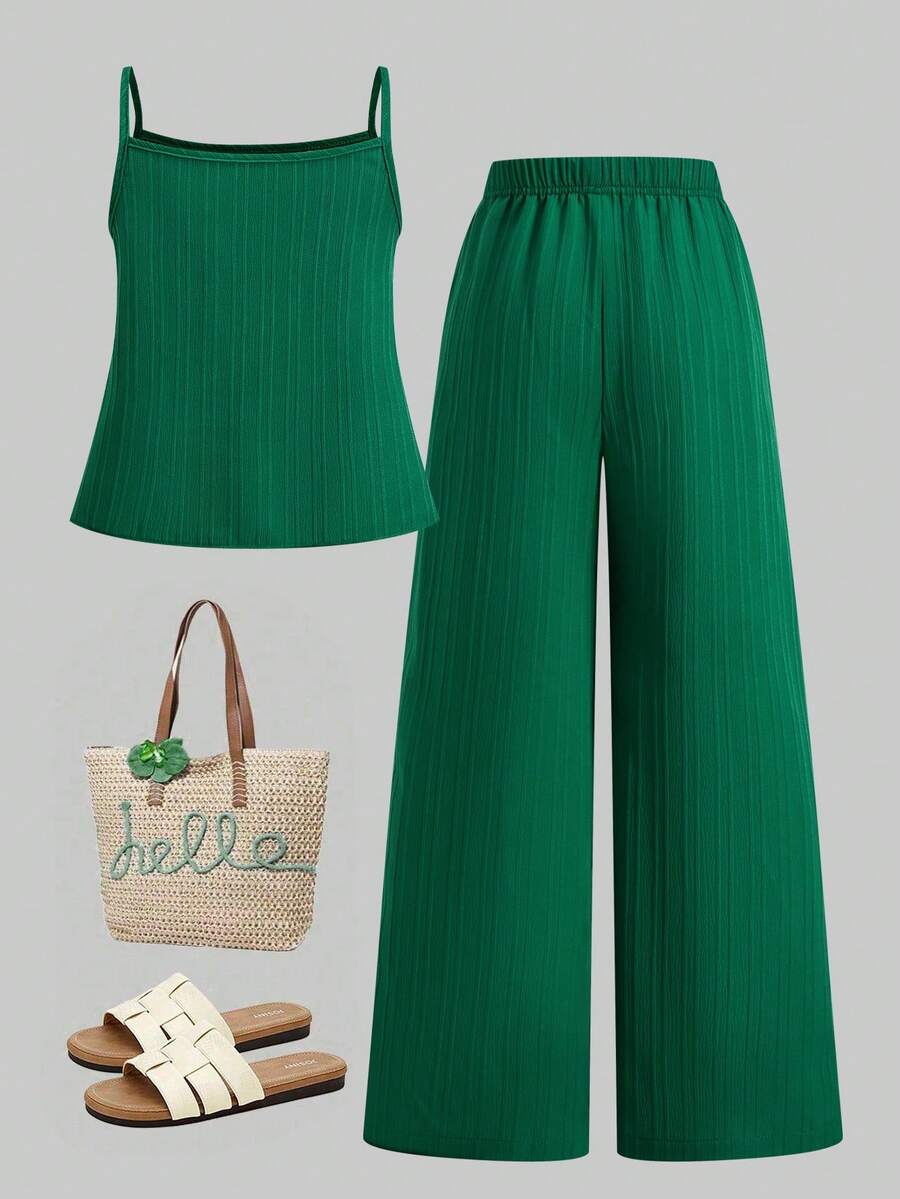 Tween girl wearing an apricot 2-piece outfit set featuring a shirred spaghetti strap short cami top and matching wide-leg long pants.