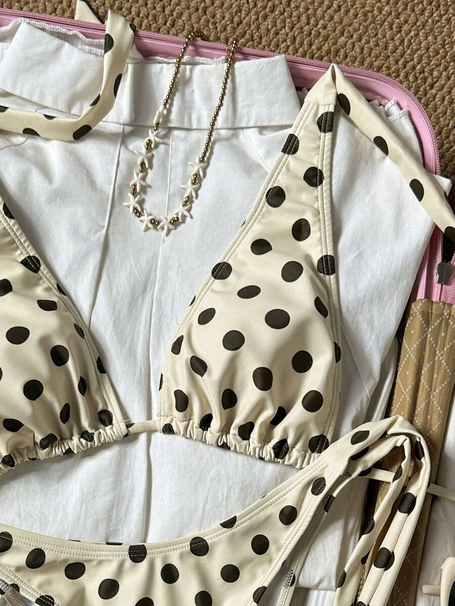 Women's polka dot two-piece bikini set featuring a backless halter top with triangle cups and matching tie-side bottoms.