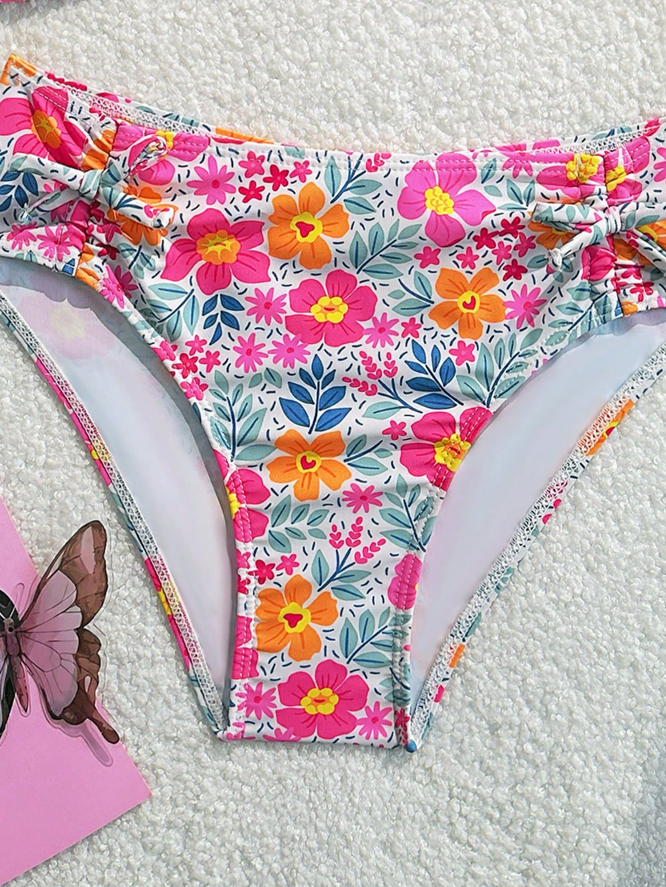 Tween girls 2-piece ditsy floral bikini set featuring a spaghetti strap top with center string detail and matching bottoms with side strings, designed for swimming, vacation, and summer wear.