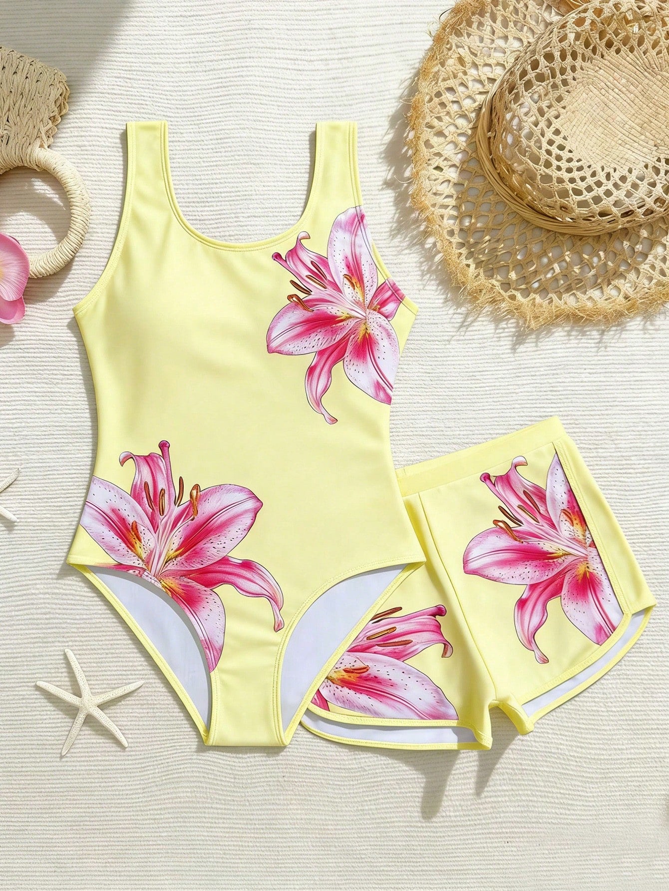 Tween girls 2-piece swimsuit set in black with full floral and plant print, featuring a sleeveless scoop-neck swim top and matching shorts-style bottoms.