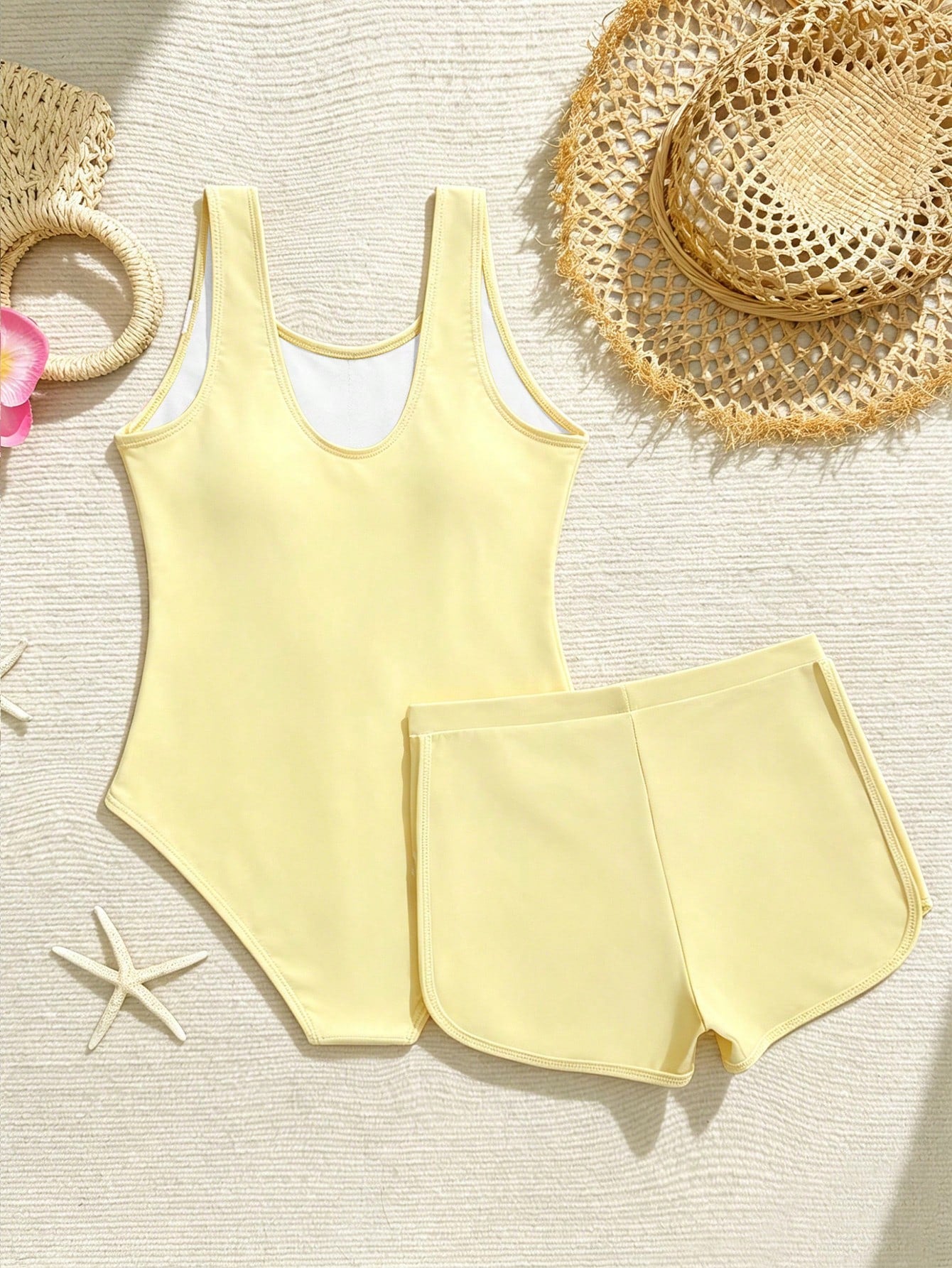 Tween girls 2-piece swimsuit set in black with full floral and plant print, featuring a sleeveless scoop-neck swim top and matching shorts-style bottoms.