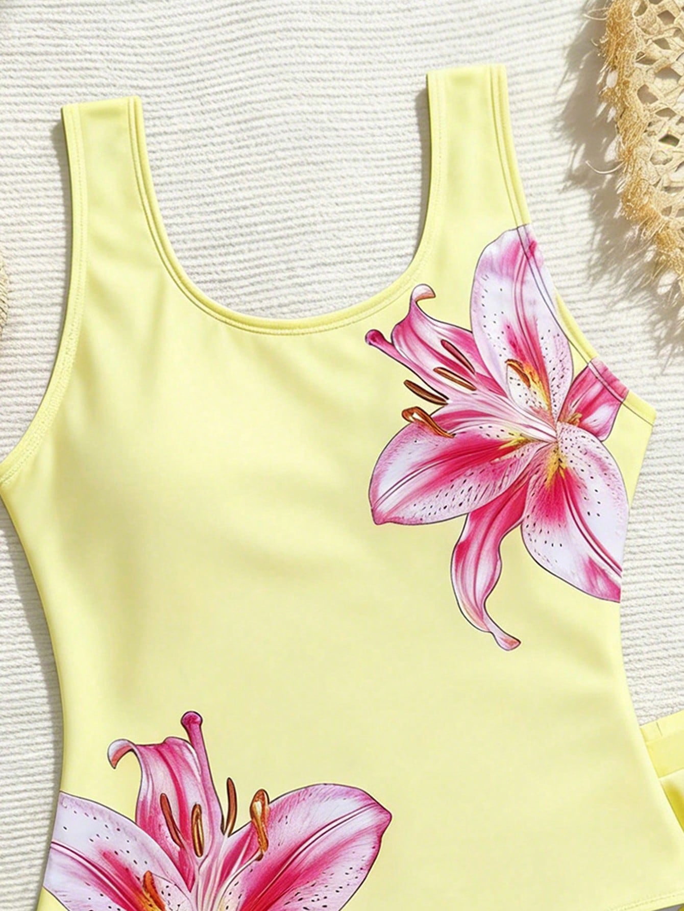 Tween girls 2-piece swimsuit set in black with full floral and plant print, featuring a sleeveless scoop-neck swim top and matching shorts-style bottoms.