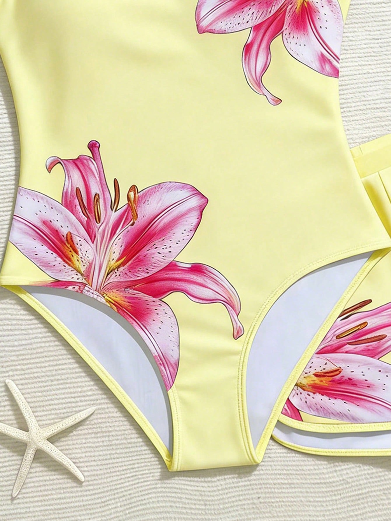 Tween girls 2-piece swimsuit set in black with full floral and plant print, featuring a sleeveless scoop-neck swim top and matching shorts-style bottoms.