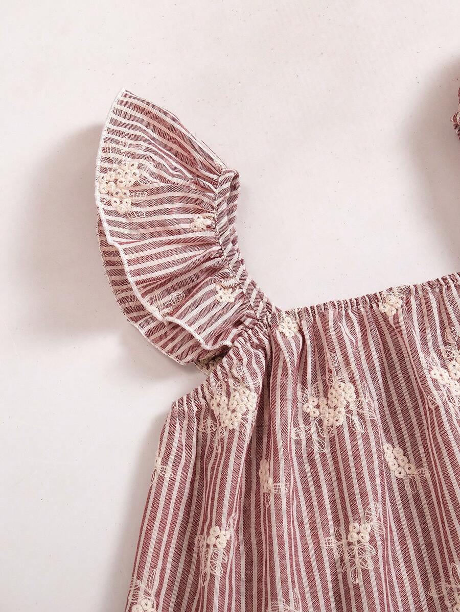 Tween girl wearing a blue and white striped sleeveless top featuring embroidery details and ruffle trim with matching shorts.