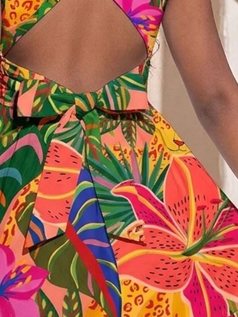 Pink sleeveless tween girls vacation dress with all-over fruit and vegetable print, strap neckline, belted high waist, cut-out detail, and flared ruffle hem.