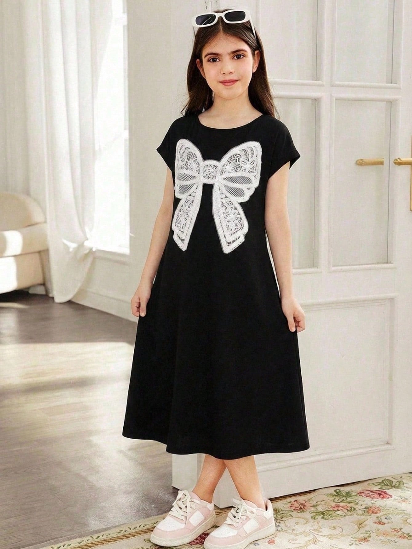 Tween girls casual black A-line long dress featuring short sleeves, a round neckline, and a decorative front bow with contrast lace trim.
