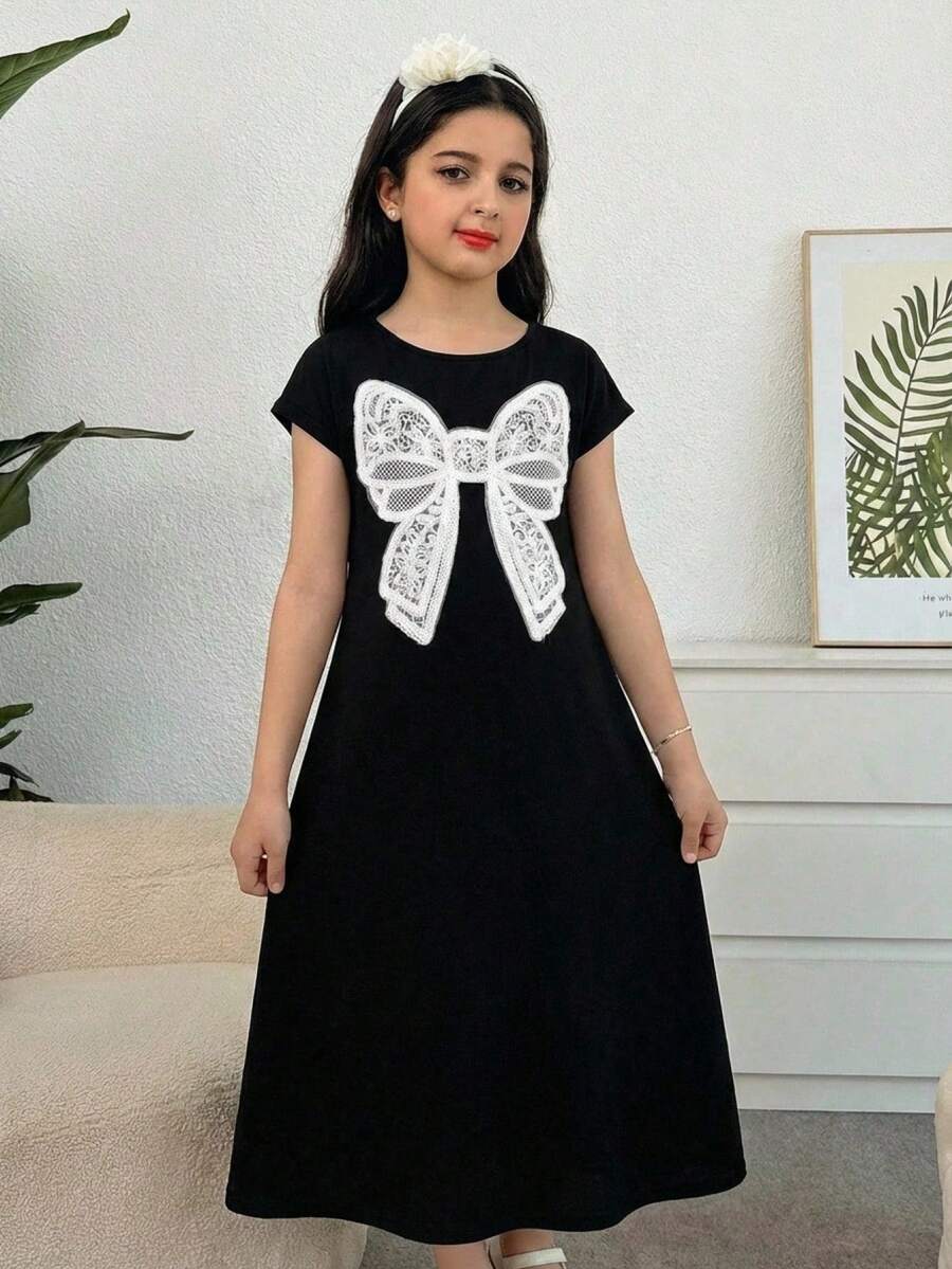 Tween girls casual black A-line long dress featuring short sleeves, a round neckline, and a decorative front bow with contrast lace trim.