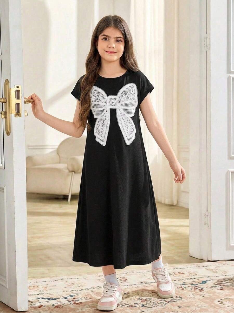 Tween girls casual black A-line long dress featuring short sleeves, a round neckline, and a decorative front bow with contrast lace trim.