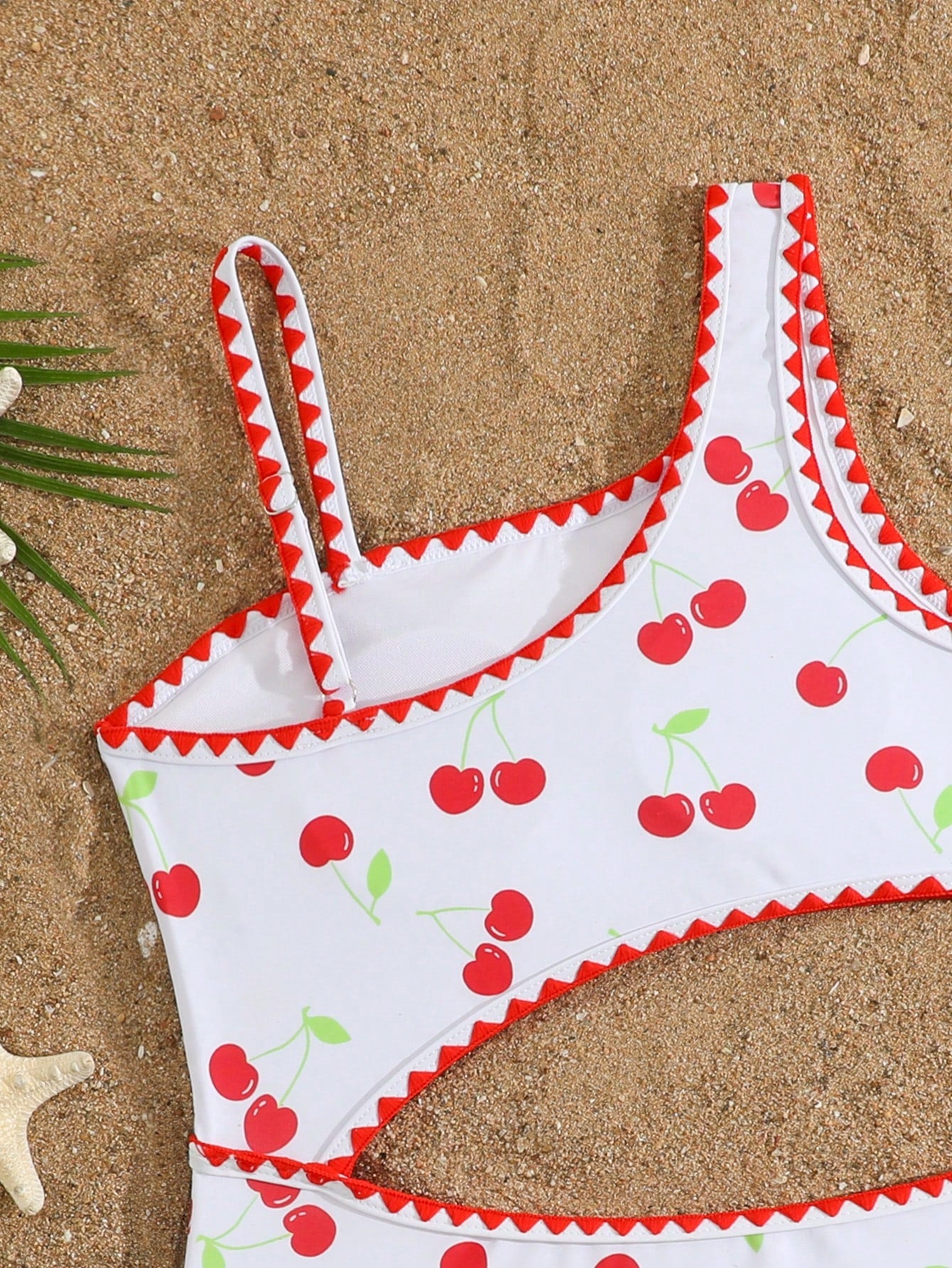 Tween girls one-piece swimsuit featuring an asymmetric neckline, pendant decor, plain design, wireless bra, high-cut bottom, and medium-stretch fabric.