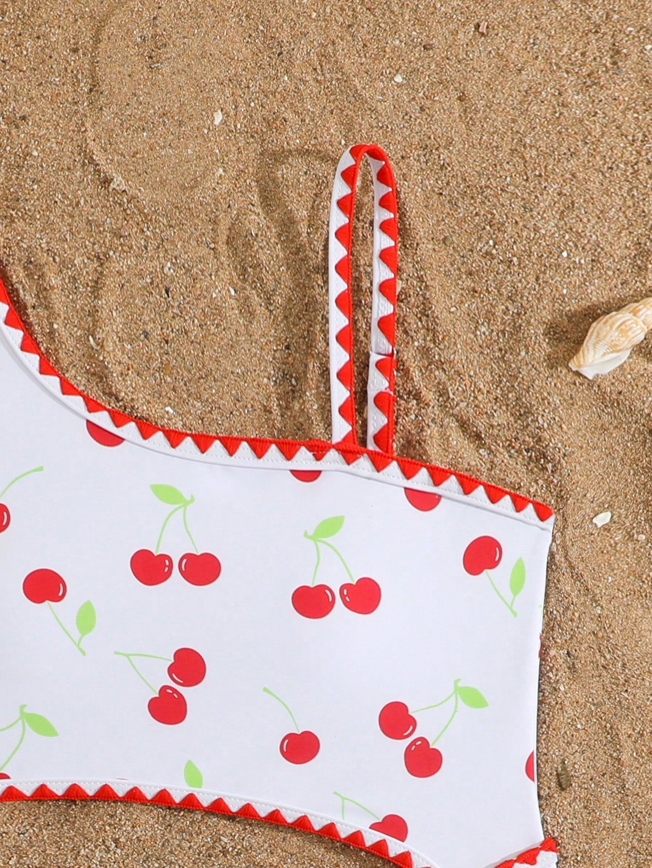 Tween girls one-piece swimsuit featuring an asymmetric neckline, pendant decor, plain design, wireless bra, high-cut bottom, and medium-stretch fabric.