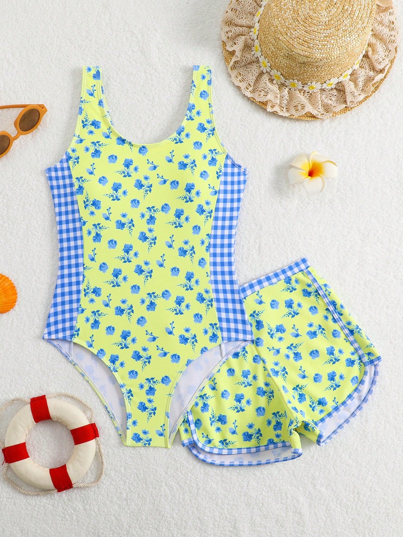 Tween girls 2-piece swimsuit set in black with full floral and plant print, featuring a sleeveless scoop-neck swim top and matching shorts-style bottoms.
