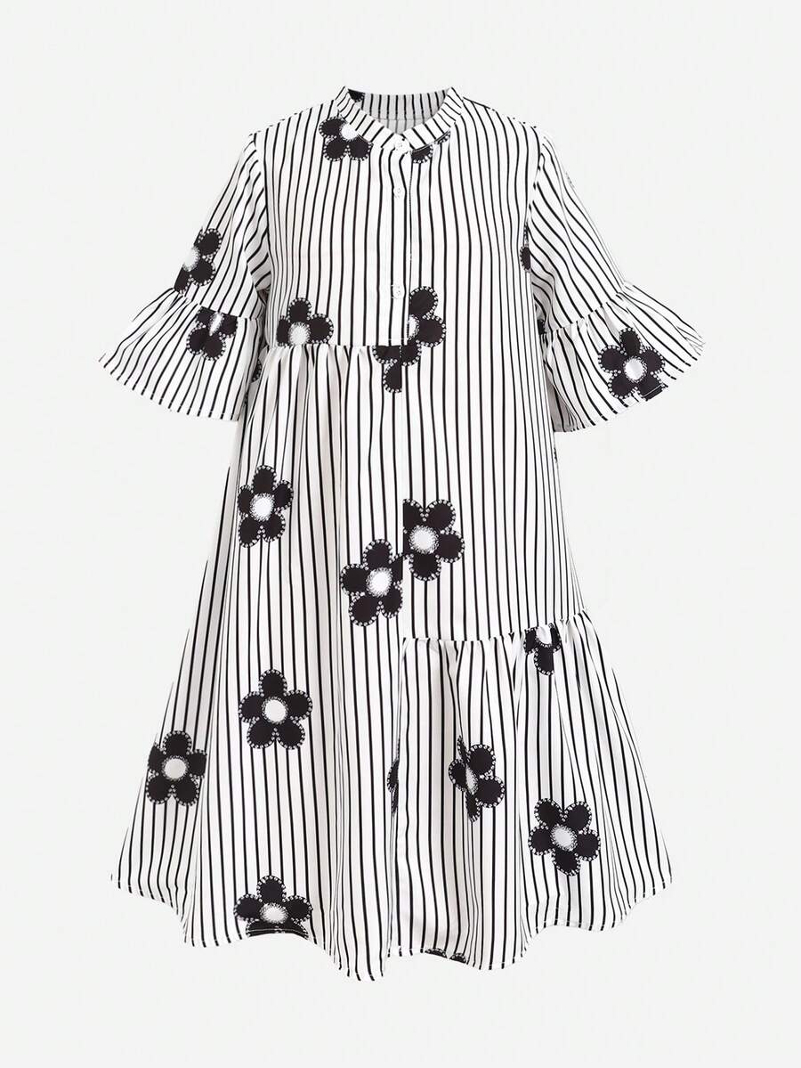 Tween girl wearing a black striped smock shirt dress with flounce half sleeves, a stand collar, and a ruffled hem.
