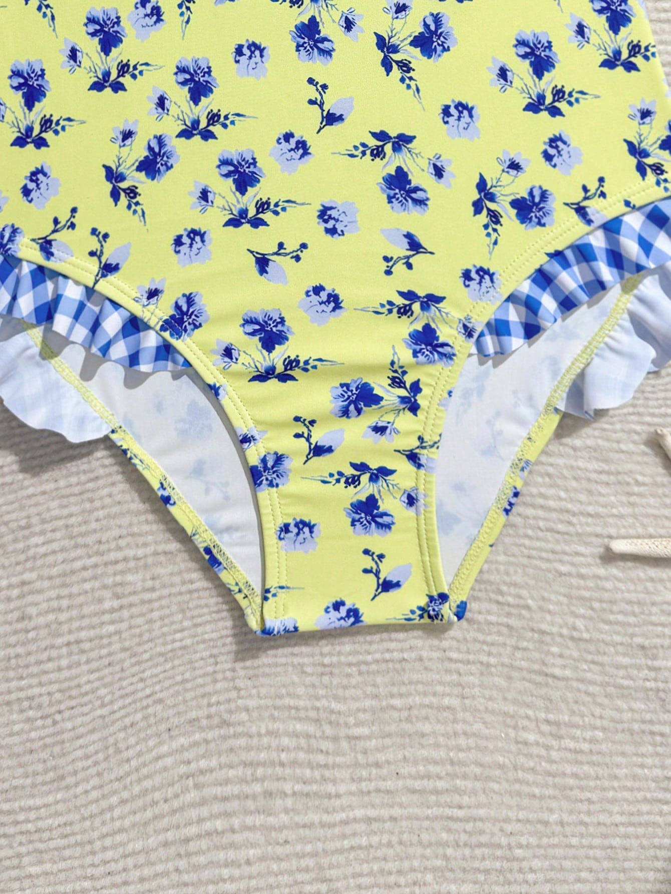 Tween girl plaid all-over print one-piece swimsuit with ruffle detail, spaghetti straps, fitted shape, and multicolor patchwork style for beach or pool wear.