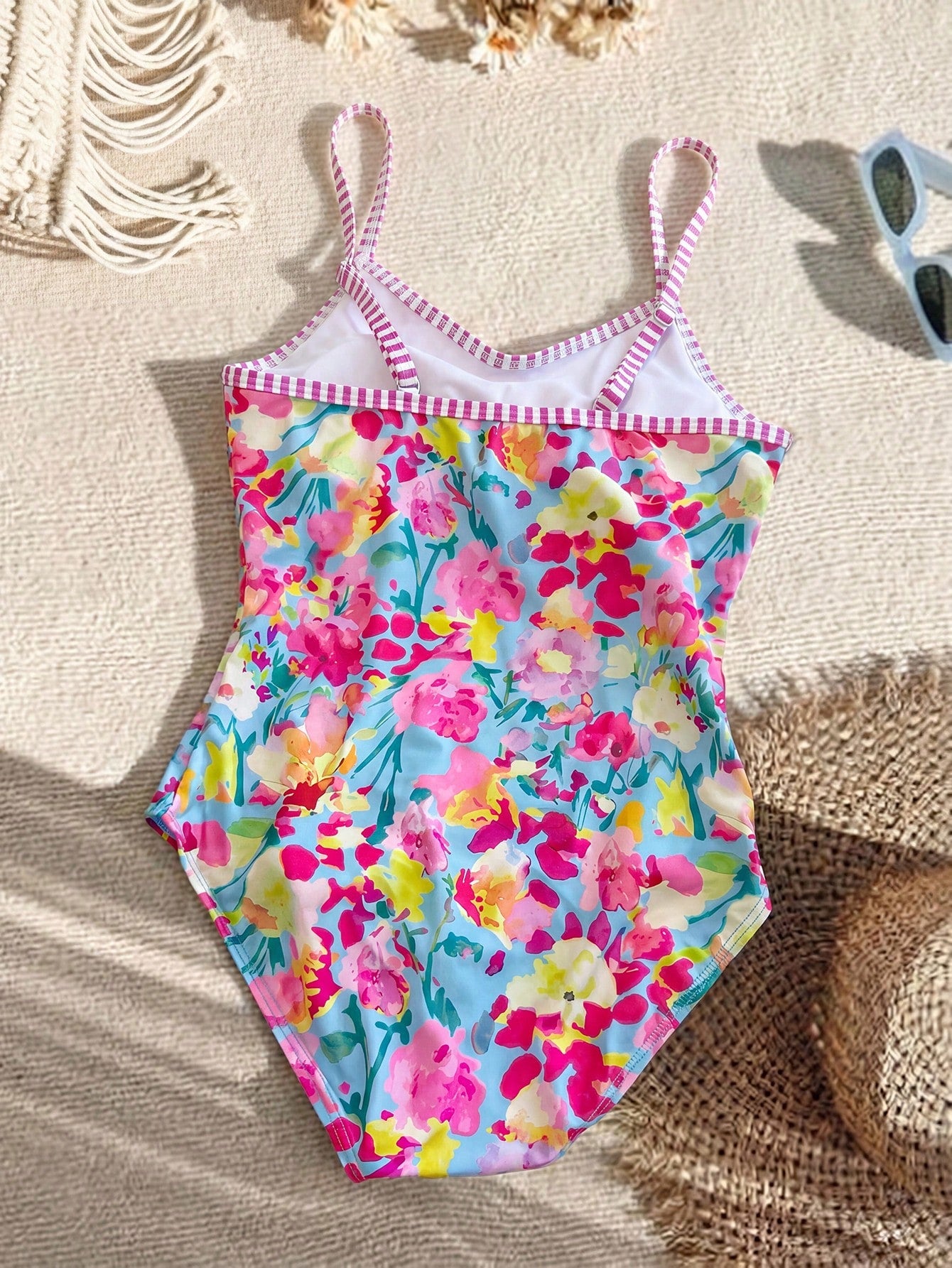 Tween girls' one-piece swimsuit featuring a ruffle splice front, ruched detailing, bow accent, contrast lace trim, and spaghetti straps.
