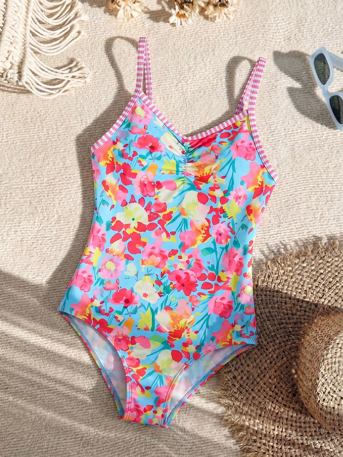 Tween girls' one-piece swimsuit featuring a ruffle splice front, ruched detailing, bow accent, contrast lace trim, and spaghetti straps.