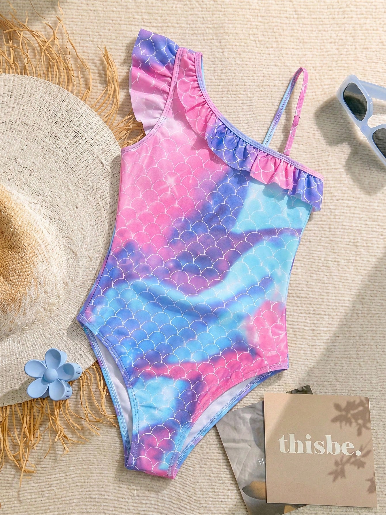 Tween girl one-piece swimsuit in brown polka dot geometric print with asymmetrical neckline, ruffle detail, cut-out design, and fitted mid-waist swim bottom.