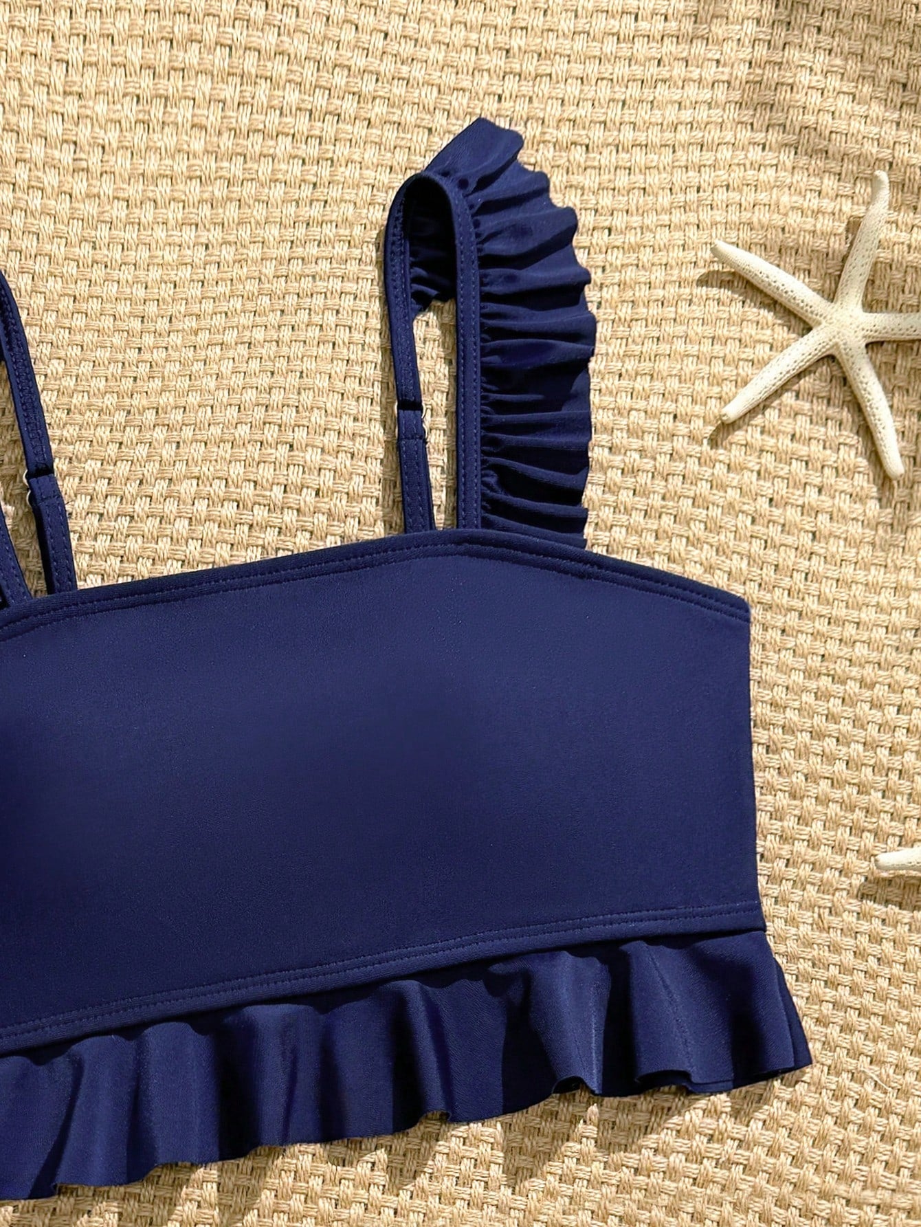 Tween girls solid color 2-piece bikini swimwear set with ruffle detail, strap neckline, wireless bikini top, and triangle mid-waist bikini bottoms; textured pattern with lined bottoms and high-stretch fabric, suitable for summer vacation.