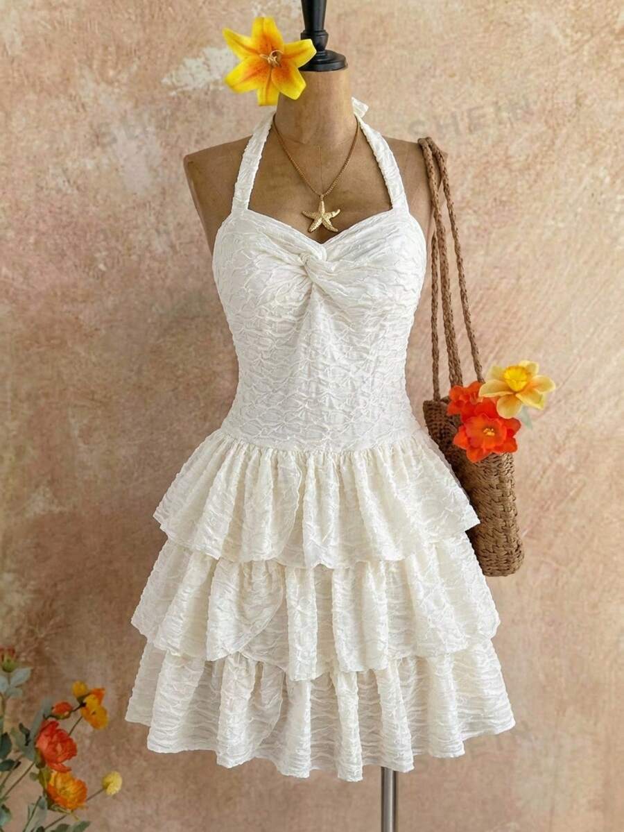 Beige tween girls halter dress with textured jacquard fabric, plant pattern, shirred detail, zipper closure, and layered tiered ruffle hem for vacation wear