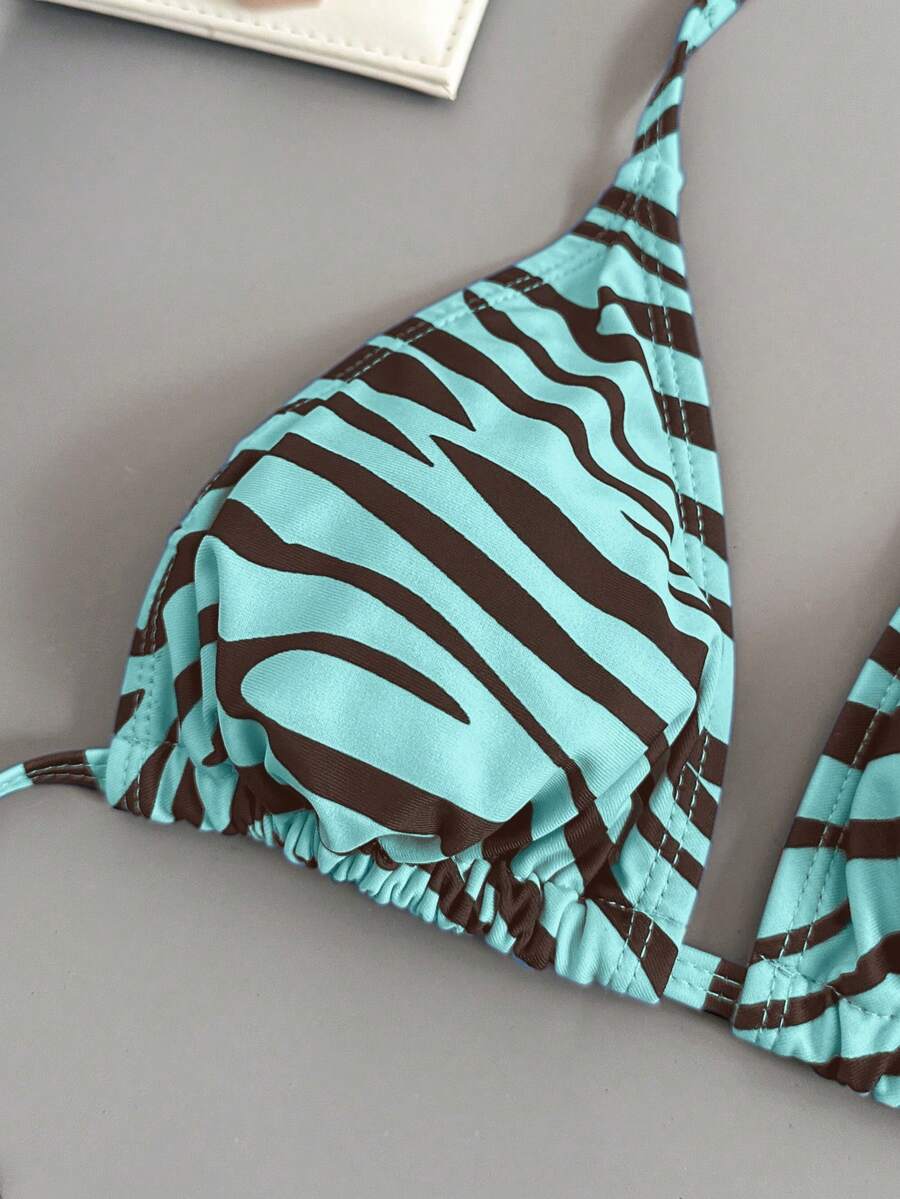 Women's black and white zebra print two-piece bikini set featuring a high waist tie-side bottom and a backless halter top with removable padding.