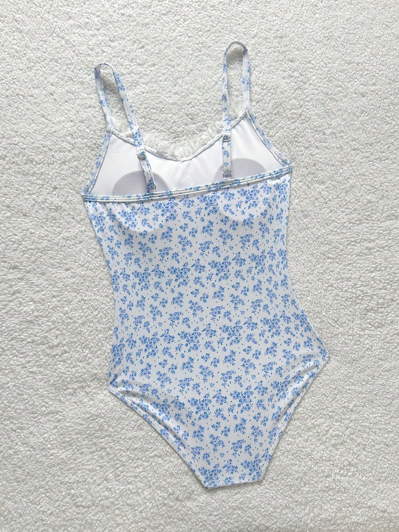 Tween girls' one-piece swimsuit featuring a ruffle splice front, ruched detailing, bow accent, contrast lace trim, and spaghetti straps.
