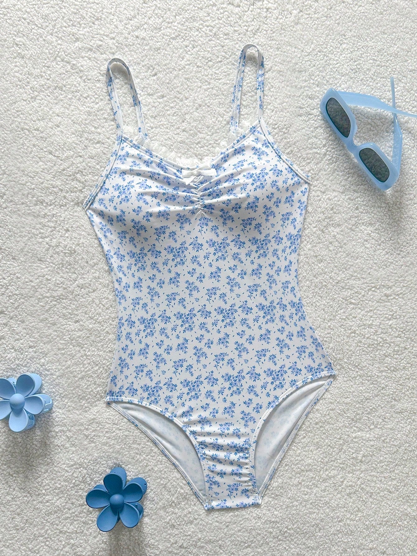 Tween girls' one-piece swimsuit featuring a ruffle splice front, ruched detailing, bow accent, contrast lace trim, and spaghetti straps.