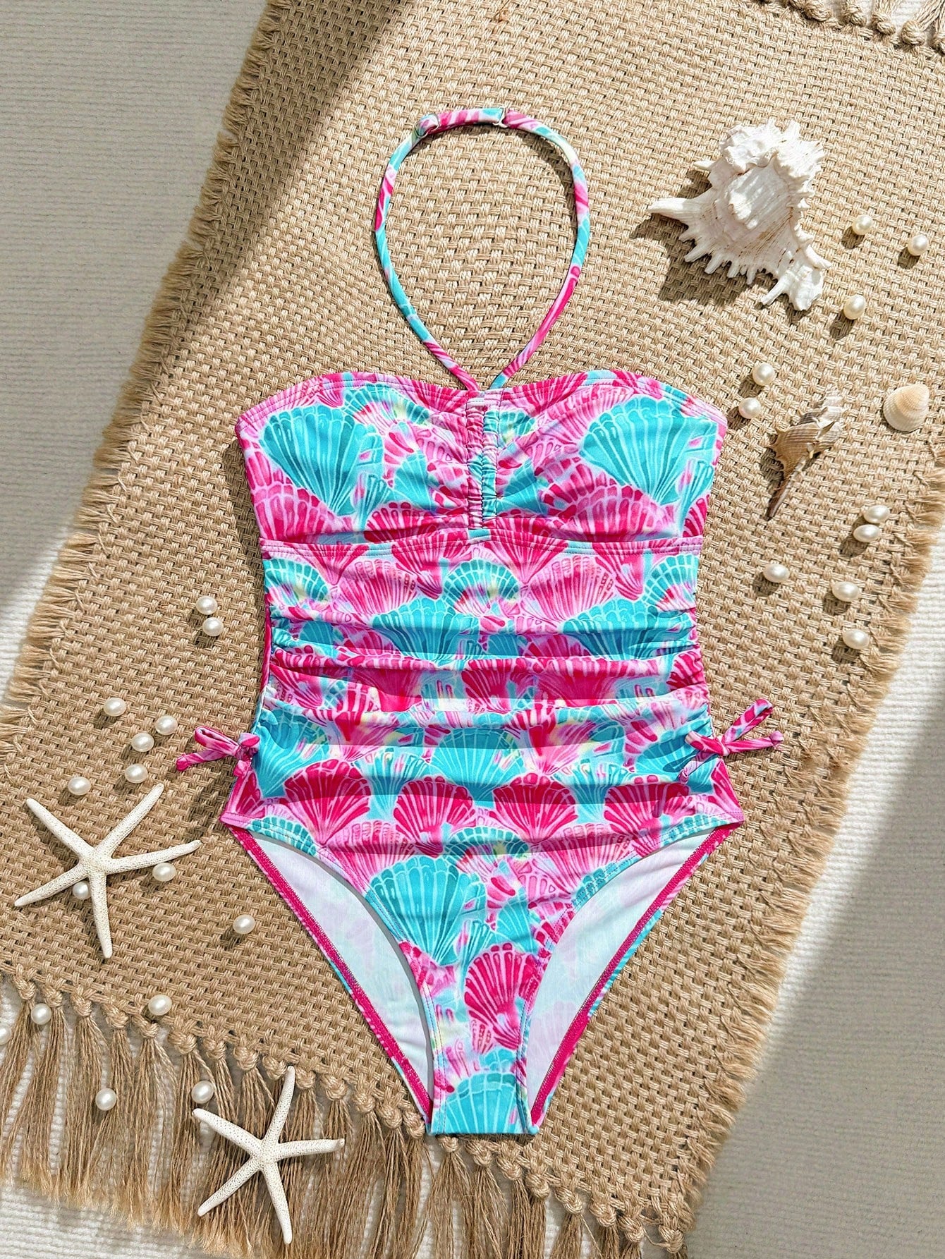 Blue halter one-piece swimsuit for tween girls with full geometric print, wireless bra design, mid-waist bottom, and medium-stretch fabric for beach and pool wear.
