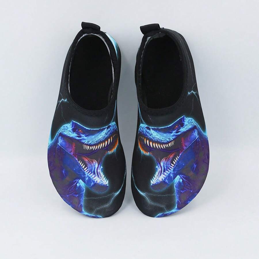 Multicolor boys water shoes featuring a cartoon Tyrannosaurus Rex print, breathable Lycra upper, slip-on stretch collar, and flexible non-slip rubber outsole.