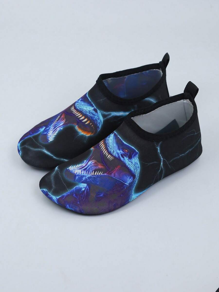 Multicolor boys water shoes featuring a cartoon Tyrannosaurus Rex print, breathable Lycra upper, slip-on stretch collar, and flexible non-slip rubber outsole.