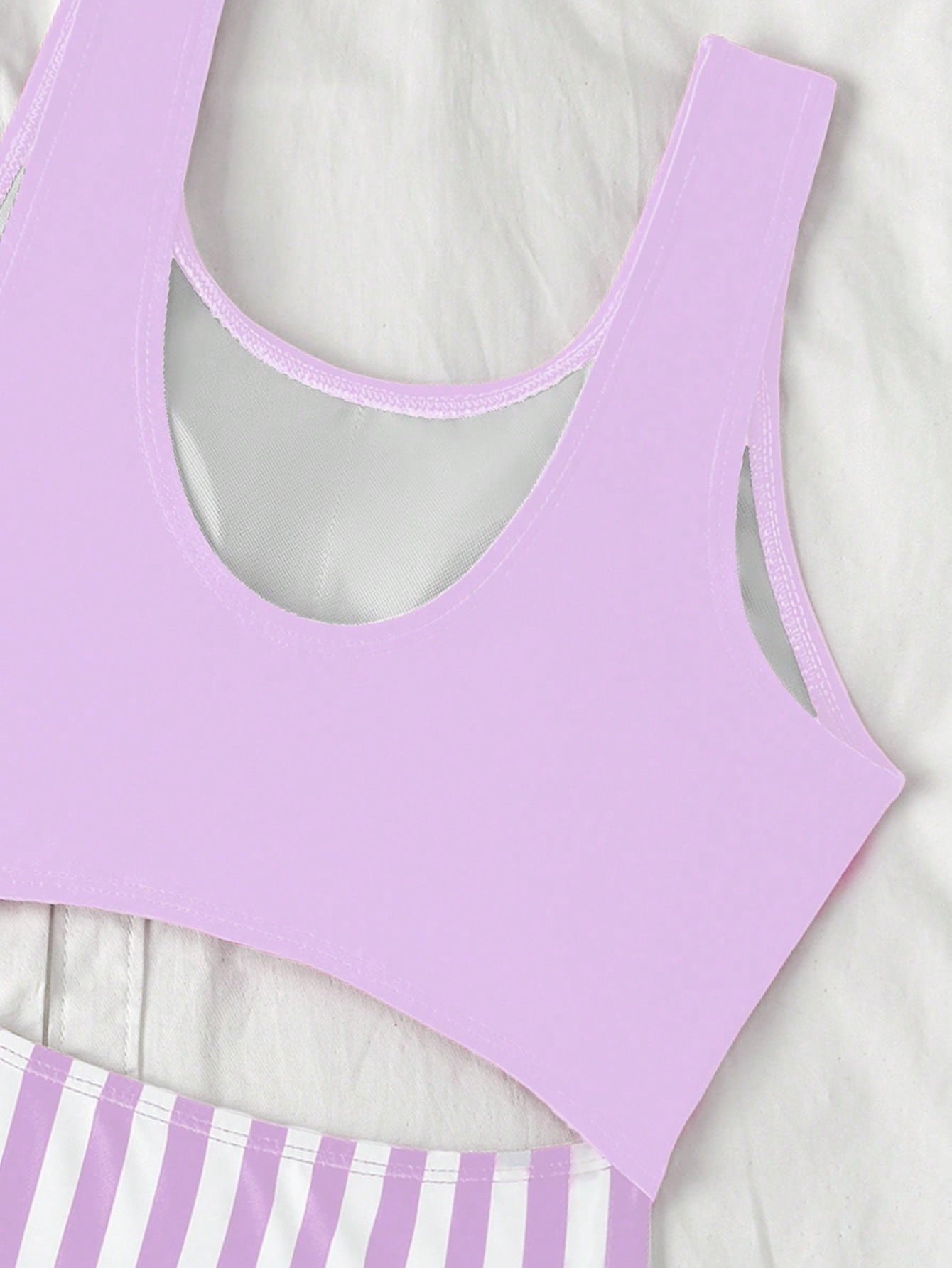 Purple tween girls one-piece swimsuit with asymmetrical neckline, cut-out waist, striped pattern, fitted silhouette, and lined body.