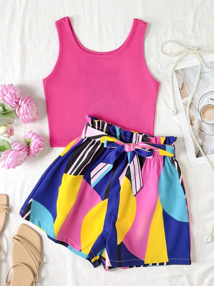 Tween girl summer two-piece outfit featuring a white scoop neck tank top and green ditsy floral print paperbag waist shorts with belt.