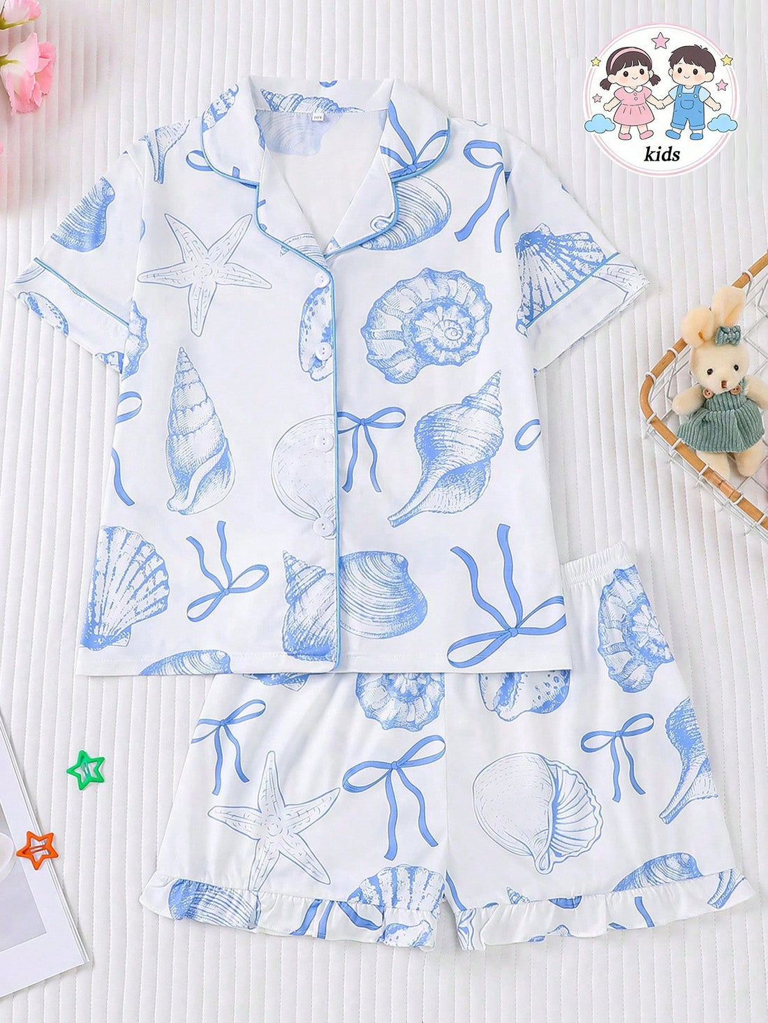 White 2-piece tween girl summer pajama set with blue ocean and seashell print featuring a short sleeve lapel cardigan top and matching elastic waist shorts.