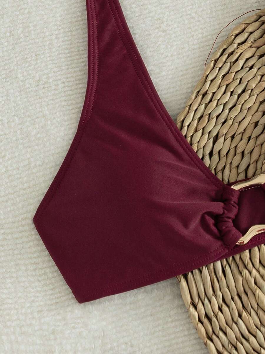 Women's 2-piece solid color halter bikini set featuring a backless tie-back wireless top and mid-waist swimsuit bottoms.